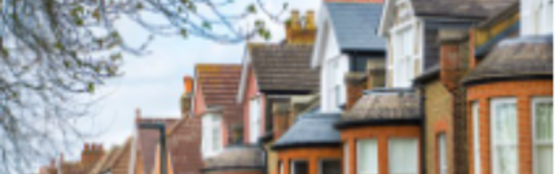 Row of traditional UK terraced houses, featuring brickwork and bay windows.