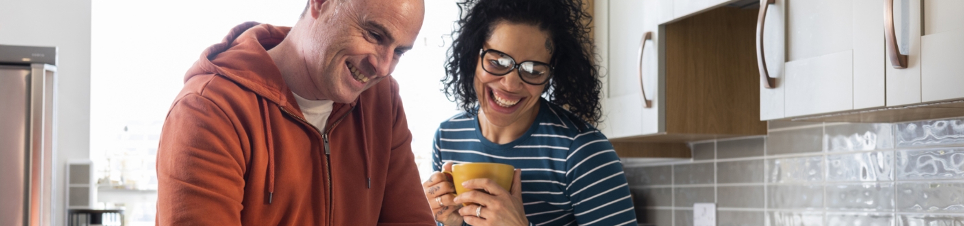 Couple in a kitchen looking at a laptop
