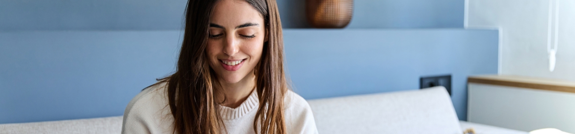Woman sitting on a sofa entering card details onto a phone
